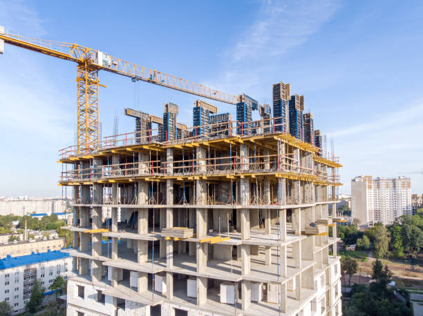istock new apartment building under construction and tower crane against blue sky background 1014002270