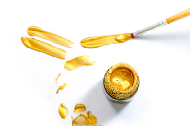 istock Acrylic gold paint in glass on a white background 1014011570