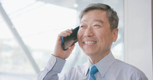 istock old businessman speak phone 1014015204