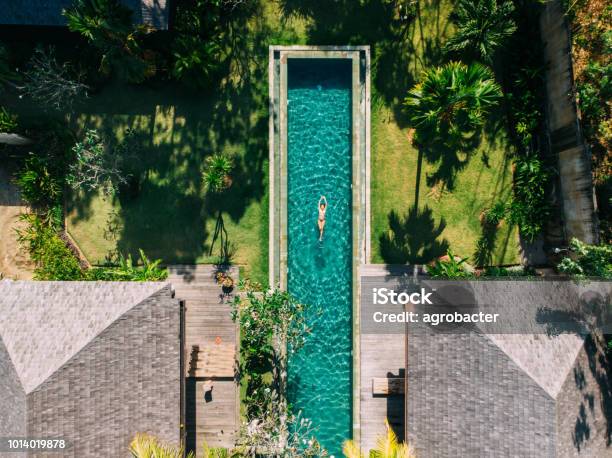 Woman Floating On Tropical Waters Stock Photo - Download Image Now - Swimming Pool, Luxury, Bali