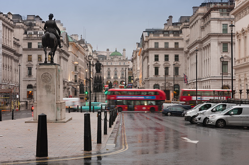 Public transport in Waterloo place in rainy early morning in London, United Kingdom