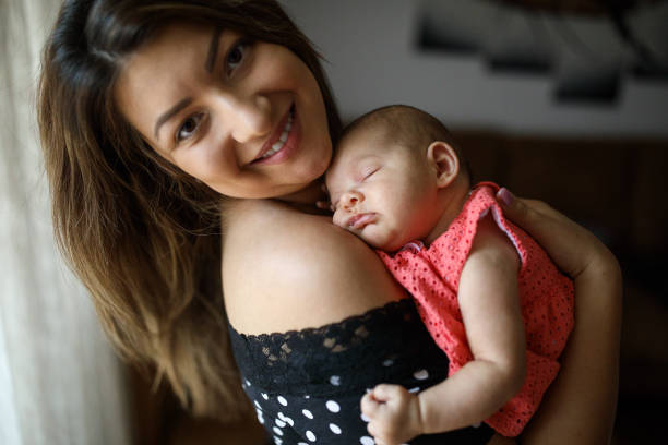 istock Baby sleeping in  mother's arms 1014025568