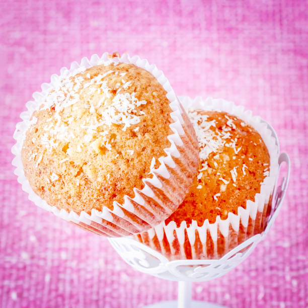 istock Square photo. Vanilla muffins with coconut powder. Pink background. Copy space. Selective focus. Toned image. 1014025672