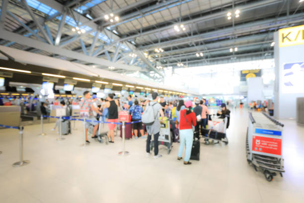 istock Blurred image of airport check-in counters with passengers and crowd of people control barriers with bokeh in international airport, que, travel, tourism, business concept Abstract Blur Background. 1014025930