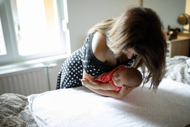 istock Baby sleeping in  mother's arms 1014028438