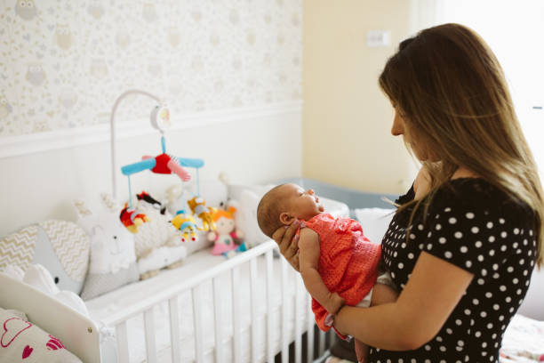 istock Baby sleeping in  mother's arms 1014028630
