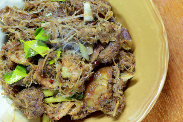 istock Northern Thailand local dish called Kaeng Hor is Northern mixed curry with vermicelli, Lime leaf galanga, red eggplant, lemon grass, lemon leaf, kaffir lime leaf in white plate. Thai Cuisine. 1014032648