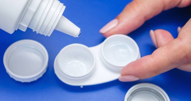istock Woman's hand with contact lens, storage case and bottle with solution for all types of soft contact lenses. 1014044280
