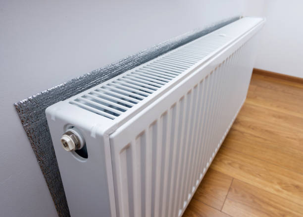 istock White metal heating radiator forming part of a central heating system with energy-efficient thermal insulation on the wall 1014044304