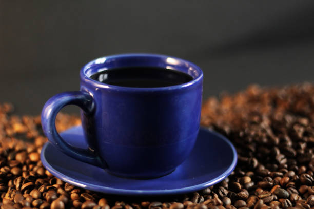 istock Blue coffee cup and plate, roasted coffee beans, black background 1014047816