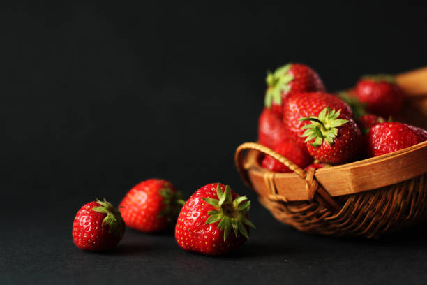 Fresh strawberries and the basket, black background