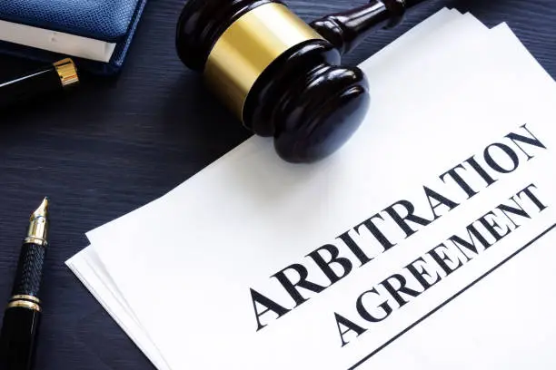 Photo of Arbitration agreement and gavel on a desk.