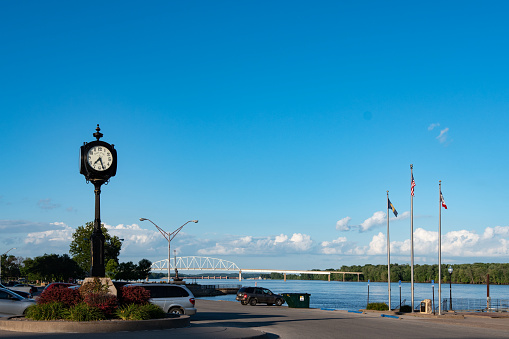 Muscatine, Iowa/USA- July 17, 2018: A view of the clock along the waterfront in downtown Muscatine with the Norbert F. Buckley Bridge in the background.