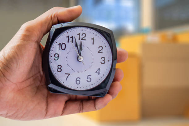 istock Holding clock on blurred background The time 12:00 am or pm and noon or midnight for made clock isolated or White background Copy space move to clipping path 1014056716