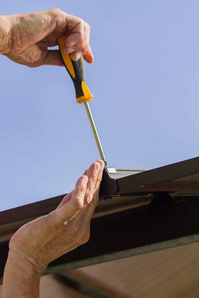istock screwdriver in males hands. Worker with a hand tool assembling metal construction outdoors 1014059868