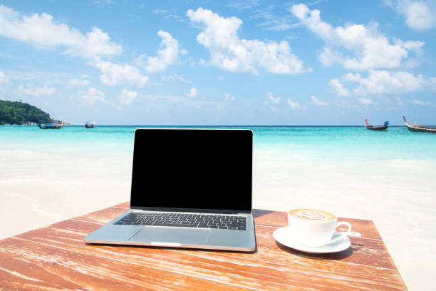 istock Laptop Computer And Coffee Cup On The Table At Seaside 1014062756