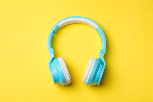 istock Blue modern wireless headphones on yellow background 1014066548