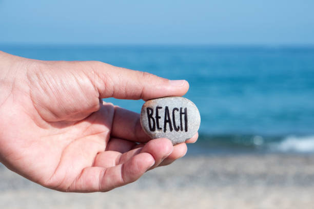 istock man on the beach and word beach 1014069428