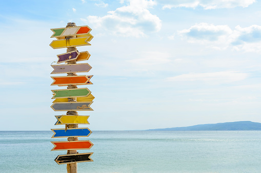 Multiple blank signs on a wooden pole in the beach.place for text.