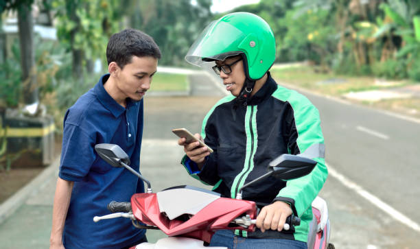 istock Young man motorcycle taxi driver checking passenger order 1014072500