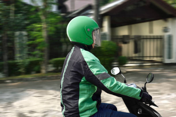 istock Young motorcycle taxi driver with green helmet 1014073130