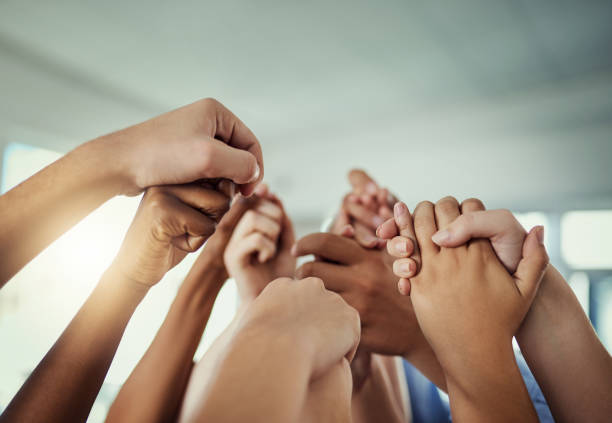 Cropped shot of a group of businesspeople holding hands in solidarity