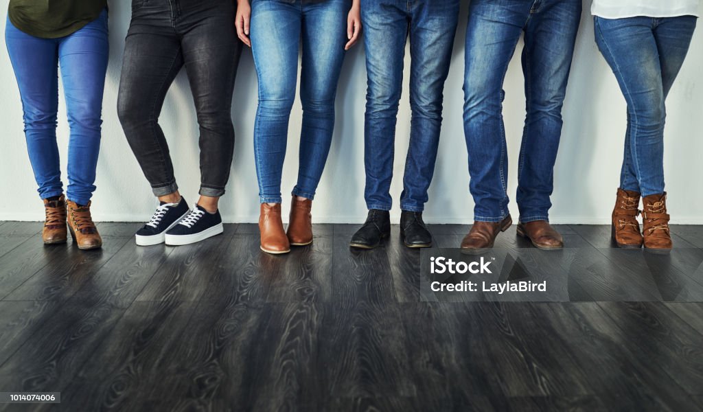 Denim - let's get back to basics Cropped shot of a group of unrecognizable people wearing jeans while standing in a row Jeans Stock Photo
