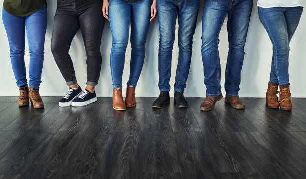 Denim - let's get back to basics Cropped shot of a group of unrecognizable people wearing jeans while standing in a row halved photos stock pictures, royalty-free photos & images
