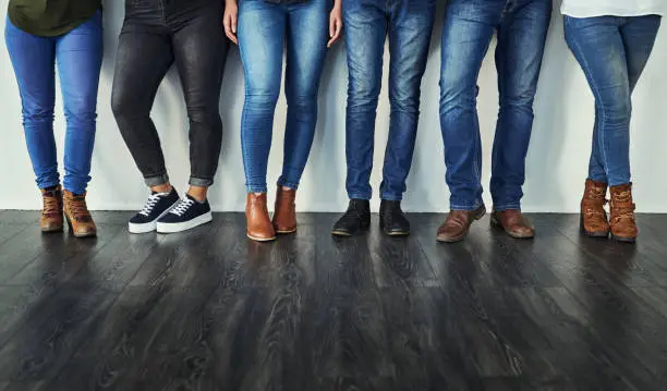 Cropped shot of a group of unrecognizable people wearing jeans while standing in a row