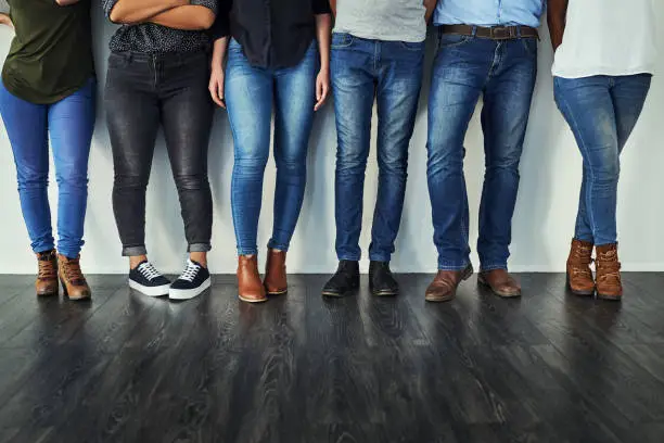 Cropped shot of a group of unrecognizable people wearing jeans while standing in a row