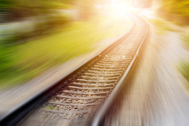 A close-up view of railway track switches, showing the intricate metal rails and mechanisms that guide trains from one track to another. The image highlights the engineering detail of the railway infrastructure, with gravel and additional tracks visible in the background.