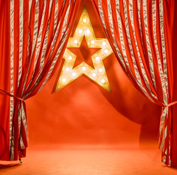 istock Striped Theatrical Curtain and Glowing Star on Red Backdrop 1014078082