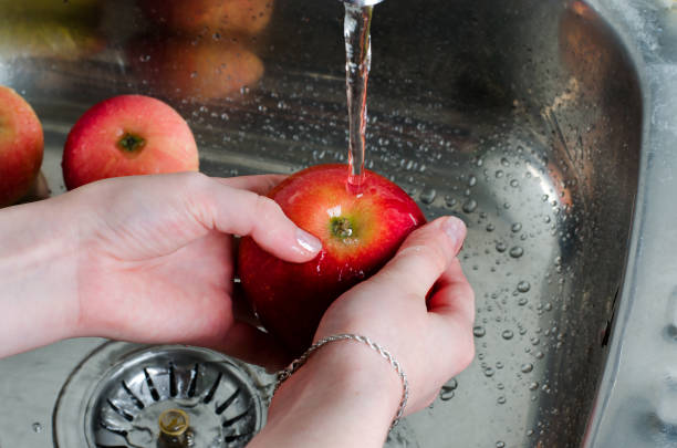 istock Food hygiene. Red apple with water splash on hands 1014081694