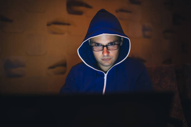 istock Hooded Man With Laptop At Night 1014086610