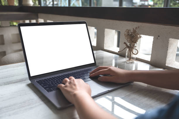 istock Mockup image of a woman using and typing on laptop with blank white screen in modern cafe 1014087048