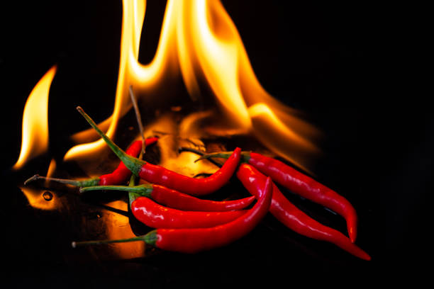 istock Fire burning hot chili on black background 1014092278
