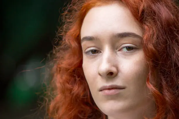 Portrait of a girl with red hair close-up without retouching.