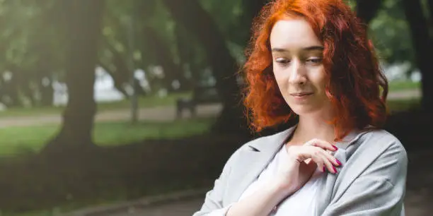 Portrait of a girl with red hair close-up in the park