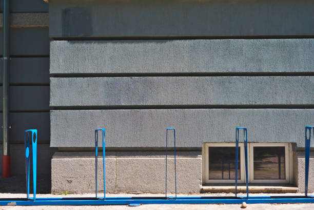 Blue bike stand in front of an emty wall.