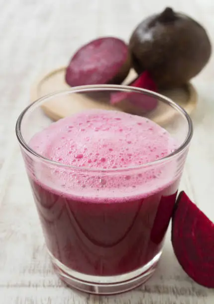 beetroot juice in glass on wood table. for health