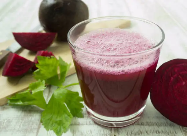 beetroot smoothie in glass on wood table. for health