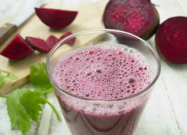 beetroot smoothie in glass on wood table. for health