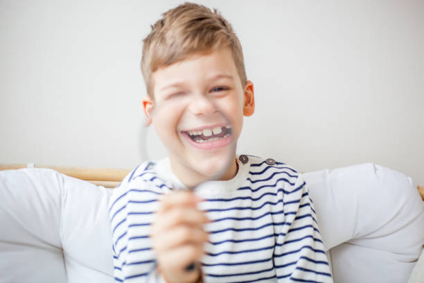 Blond hair boy having fun with magnifying glass