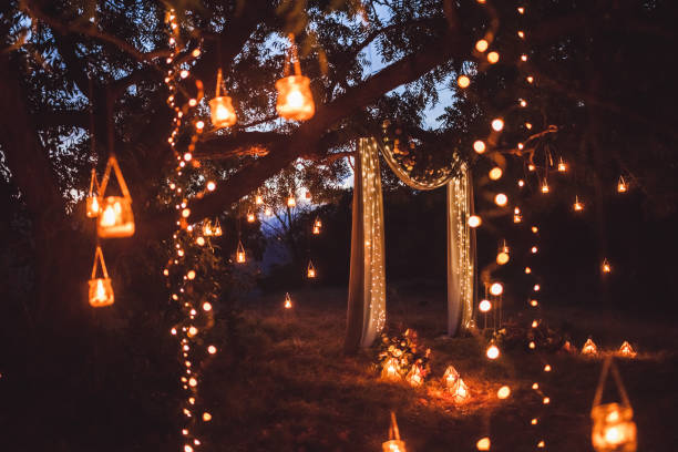 cerimônia de casamento à noite com um monte de luzes, velas, lanternas. lindo romântico brilhando decorações em crepúsculo - electric light arch architecture building exterior - fotografias e filmes do acervo