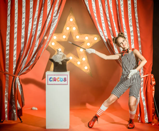 istock Cheerful Young Girl Illusionist Shows Magic Trick with Bunny and Hat 1014121698