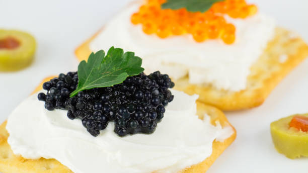 istock Black and red caviar on roasted bread served on white plate 1014121986
