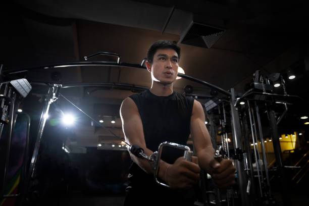 istock Bodybuilder is working on his chest with cable crossover in gym. scream for motivation 1014126654