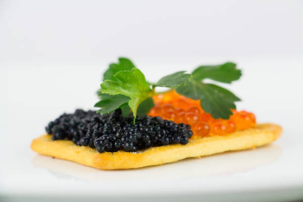istock Black and red caviar on roasted bread served on white plate 1014126694