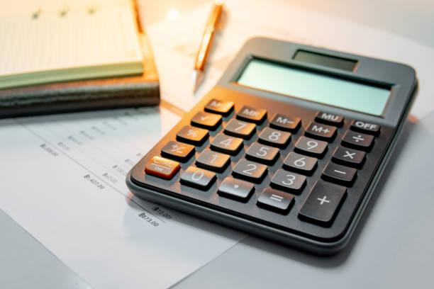 istock Calculator, pen, blank lined paper page of notebook and summary report paperwork with bar graph and table. Financial data analysis. Business planning and management concept 1014130960