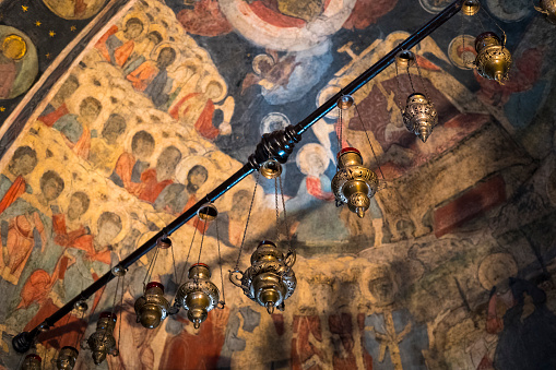 Candle lamps and paintings inside the Stavrapoleos Monastery, in the center of Bucharest.